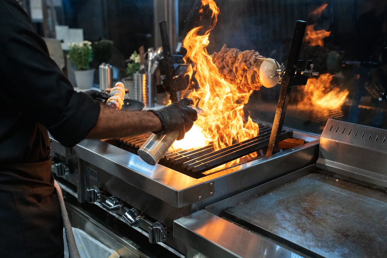 The Art of Drawing Readers In: Your attractive post title goes here Chef grilling meat with spectacular flames in a modern kitchen setup.